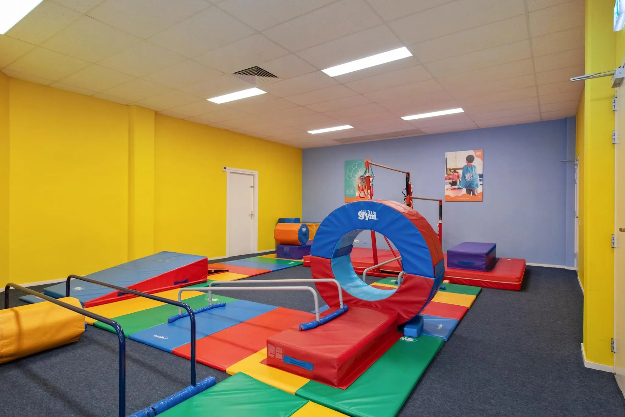 Kleurrijke binnenspeelruimte van The Little Gym aan de Koningin Julianalaan met zachte turntoestellen voor kinderen.